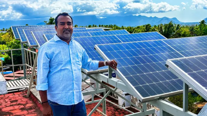 Rooftop solar panel array with hill views in Kanyakumari district