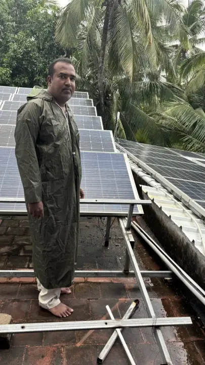 Technician inspecting rooftop solar panels during a service visit